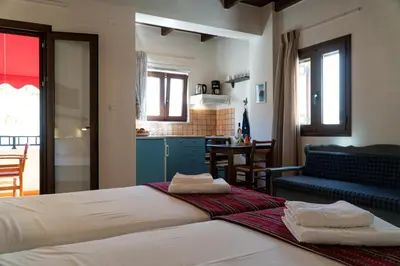 a bedroom with a bed and a living room and a kitchen at Arhondiko in Sougia
