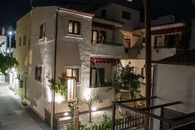 a building with a sign on the side of it at night at Arhondiko in Sougia