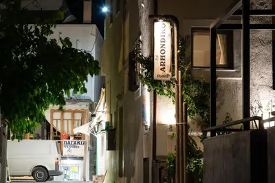 a building with a sign on the side of a street at Arhondiko in Sougia