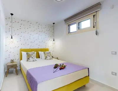 a bedroom with a bed with flowers on it at Liberty & Freedom Luxury Villa-heated pool in Plataniás