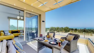 a living room with a table and chairs at Liberty & Freedom Luxury Villa-heated pool in Plataniás