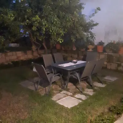 a table and chairs in a yard with a tree at Cactus in Nopíyia