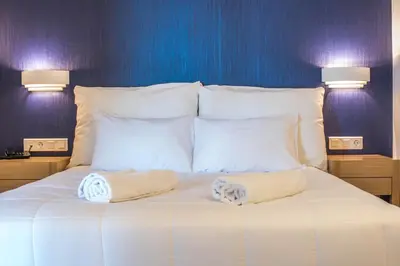 a white bed with two towels on top of it at Pal Beach in Palaiochóra