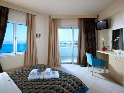 a hotel room with a bed with a view of the ocean at Molos Bay Hotel in Kissamos