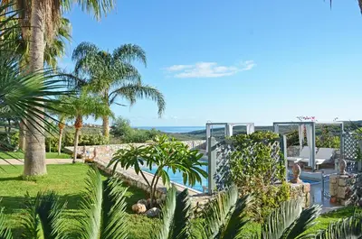 a garden with palm trees and a swimming pool at Villa Europa - Western Crete - Chania in Darmarochori