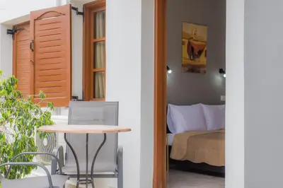a room with a table and a bed and a table at Stellar Apartments II in Plataniás