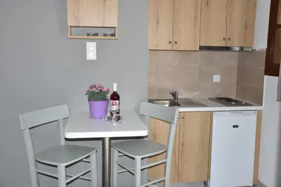a small kitchen with a small table and two stools at Stellar Apartments II in Plataniás