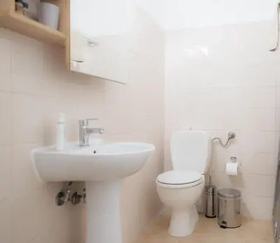 a white bathroom with a toilet and a sink at Stellar Apartments II in Plataniás