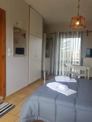 a bedroom with a blue bed in a room at Piccolo Paradiso Apartments in Kato Daratso