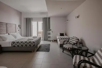 a bedroom with a bed and a couch and a table at Tellus City in Chania Town