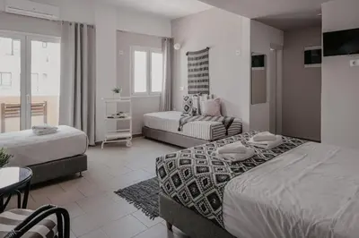 a hotel room with two beds and a couch at Tellus City in Chania Town