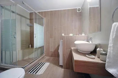 a bathroom with a sink and a glass shower at Maria's Garden in Galatás
