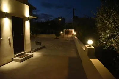 a house with a light on the side of it at night at Pirgos Deluxe Apartment - Private Parking in Kissamos