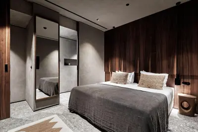 a bedroom with a large bed and a large mirror at Domes Zeen Chania, a Luxury Collection Resort, Crete in Kato Daratso