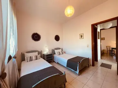 a bedroom with two beds and a table and chairs at Brina's House in Kissamos