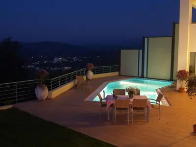 a patio with a table and chairs next to a swimming pool at Villa Rotunda A in Kolymvari