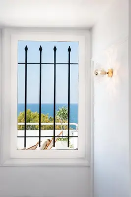 a window in a room with a view of the ocean at Alexandra's Lighthouse View in Chania Town