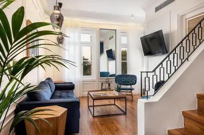 a living room with a blue couch and a table at Alexandra's Lighthouse View in Chania Town