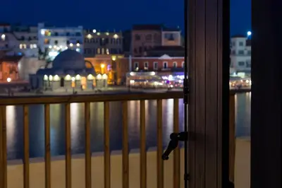 a view of a city at night from a balcony at Captain Vasilis Hotel in Chania Town