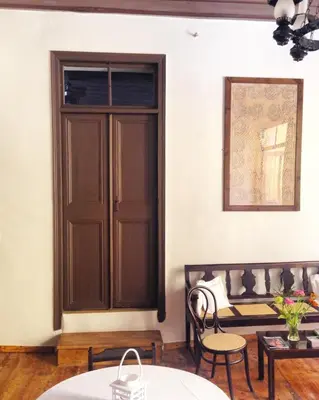 a room with a wooden door and a bench at Captain Vasilis Hotel in Chania Town