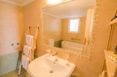 a bathroom with a sink and a mirror and a tub at La Casa Del Vitsi in Palaiochóra