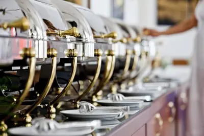 a row of white plates on a buffet line at Mrs Chryssana Beach Hotel in Kolymvari