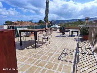 a patio with a table and chairs and an umbrella at Elvie House in Chania Town