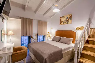 a bedroom with a white bed and a staircase at Elvie House in Chania Town
