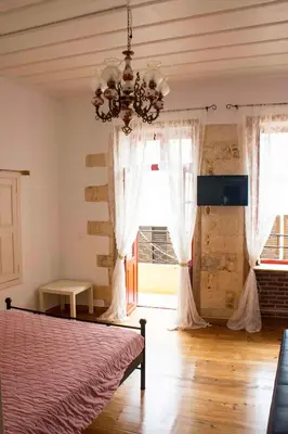 a bedroom with a bed and a chandelier at Green Door Apartment in Chania Town
