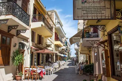 a street in a town with tables and chairs at Green Door Apartment in Chania Town