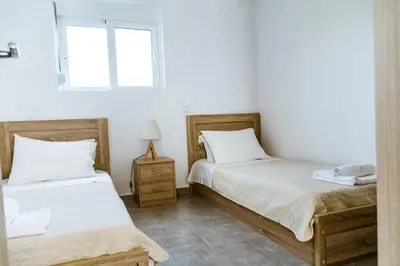 two beds in a room with white walls at Martimi Apartments - 200M from Drapanias Beach - Pool - Hot Tub - Sauna - BBQ in Kissamos