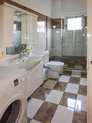 a bathroom with a toilet sink and a washing machine at Almyrida sea view house in Almirida