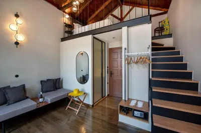 a living room with a staircase and a couch at Mosaic Venetian Harbour Suites in Chania Town