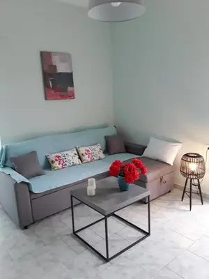 a living room with a couch and a table with flowers at Marianos Apartments in Kissamos