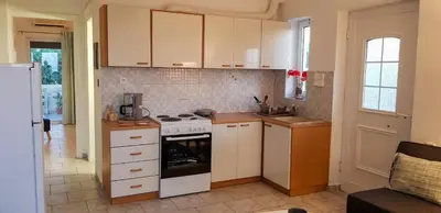 a kitchen with white cabinets and a stove top oven at Marianos Apartments in Kissamos