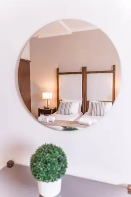 a reflection of a bedroom with a bed in a mirror at Kalamaki Mare Suites in Kalamaki Chanion