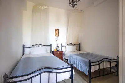 a bedroom with two beds and a dresser at Villa Seli in Gerani Chanion