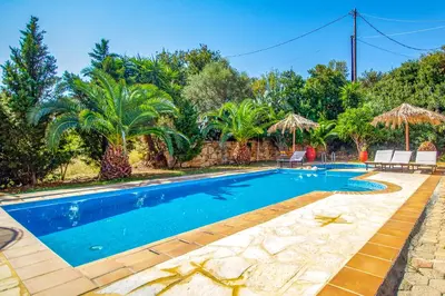 a swimming pool in a villa with palm trees at Villa Seli in Gerani Chanion