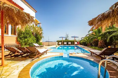 a swimming pool with chairs and a house at Villa Seli in Gerani Chanion
