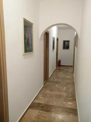 a hallway with an archway and paintings on the walls at Calypso in Agia Roumeli