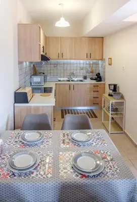 a kitchen with a table with plates on it at Seashore Apartments in Chorafakia