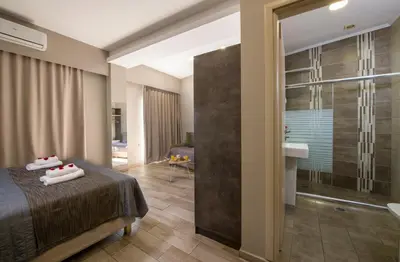 a hotel room with a bed and a shower at Stoa Suites Chania in Chania Town