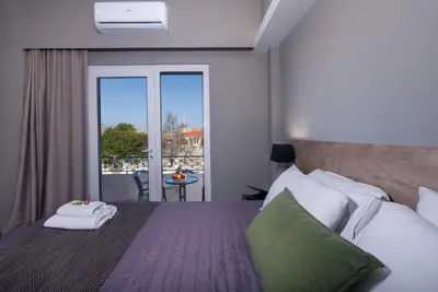 a bedroom with a bed with a view of a balcony at Stoa Suites Chania in Chania Town