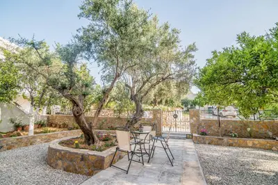 a patio with a table and chairs under a tree at Nina's House in Kamisianá