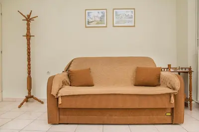 a couch in a living room with a cross on the wall at Nina's House in Kamisianá