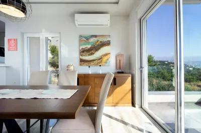 a dining room with a table and a large window at Rooftop Jacuzzi Apartment in Chania Town