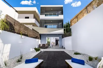 a modern house with white walls and blue cushions at Solar Apartments by Amara Living in Agia Marina Nea Kydonias