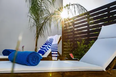 a bed with blue towels and a laptop on it at Solar Apartments by Amara Living in Agia Marina Nea Kydonias