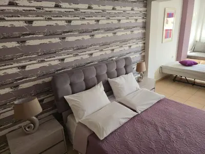 a bedroom with a bed and a wooden wall at Emily's House in Kissamos