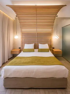 a bedroom with a large bed with a wooden headboard at Agave Suites in Chania Town